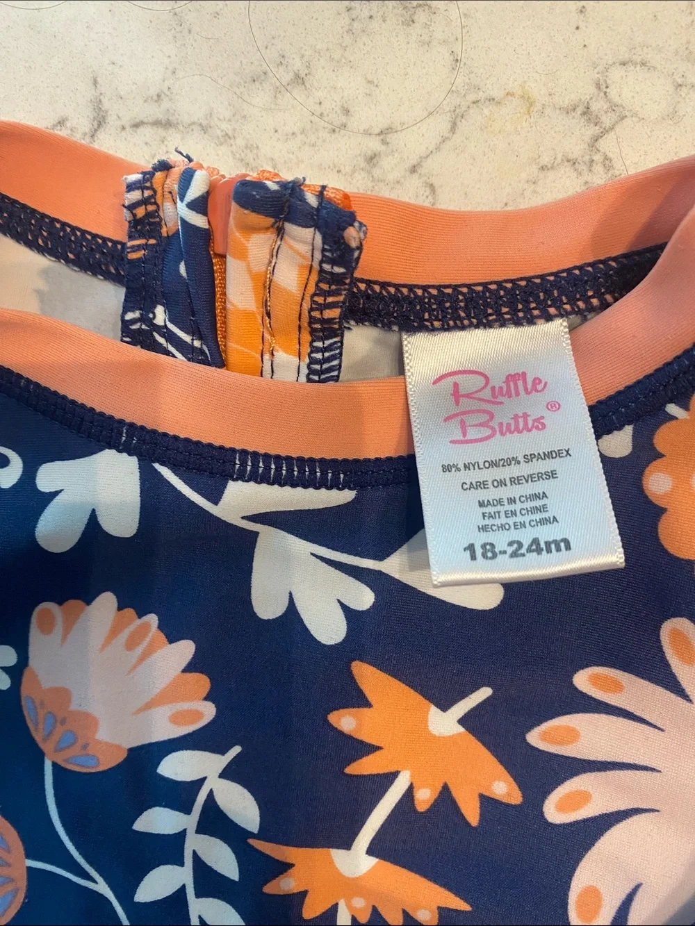 Ruffle Butts Navy Swimsuit with Peach Floral Accents